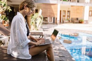 Workation: una donna lavora a bordo piscina